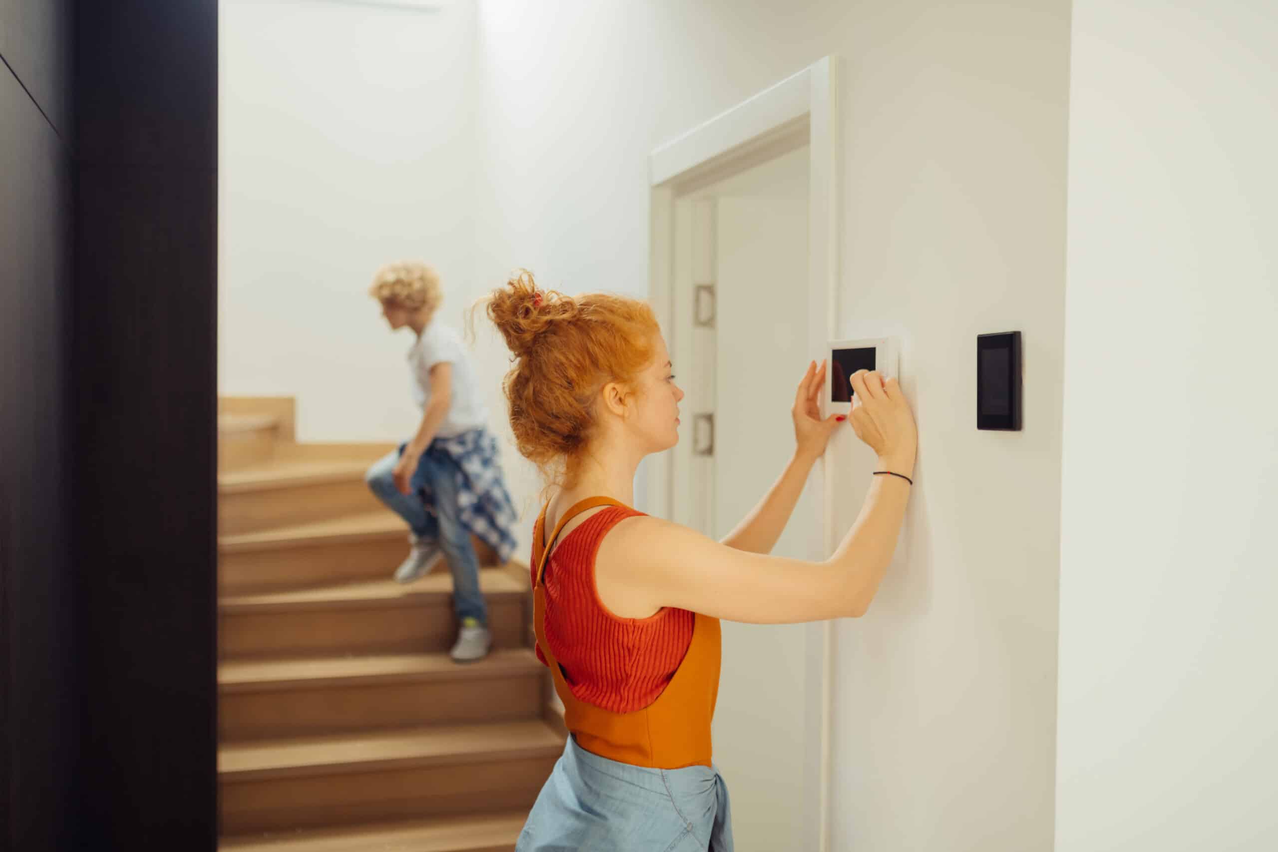 Woman checking thermostat settings
