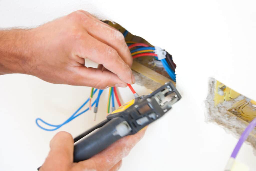 Electrician preparing cables for outlet connection